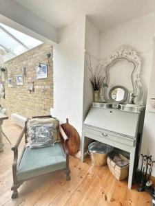 een kamer met een tafel, een stoel en een spiegel bij Home away from Home - Broadstairs beautiful family seaside house with garden and parking in Kent