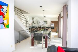 a kitchen and dining room with a dining table and a staircase at Villa Azinhança do Mar in Lourinhã
