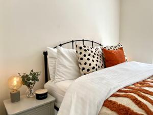 a bedroom with a bed with pillows on it at New Stylish Cambridge Townhouse (Free parking) in Long Stanton +6 photos