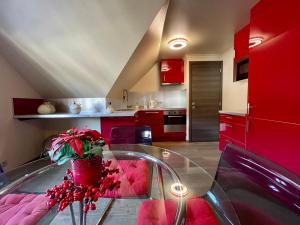 City Apartments by Malmedreams في مالميدي: مطبخ مع دواليب حمراء وطاولة زجاجية