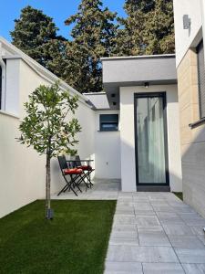 a patio with a table and a tree next to a house at Villa Laverna Annex in Novalja