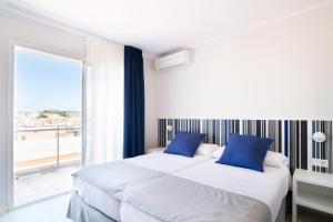 two beds in a room with a large window at Ibersol Sorra d'Or in Malgrat de Mar