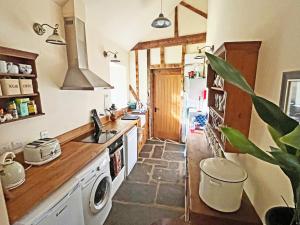 a kitchen with a sink and a stove at Drovers Retreat in Llandrindod Wells