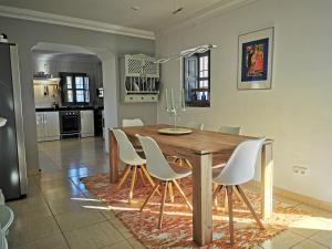 uma sala de jantar com uma mesa de madeira e cadeiras brancas em Casa Las Majadillas em Iznájar