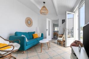 a living room with a blue couch and a table at L'Argentine, Maison typique pour 5 a Saint Gilles-croix-de-vie in Saint-Gilles-Croix-de-Vie