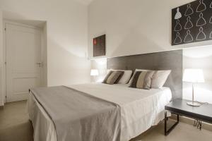 una camera bianca con un grande letto e un tavolo di Le Mummarelle Apartments a Napoli