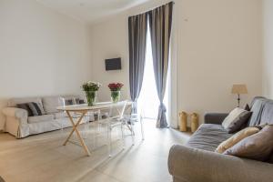 un soggiorno con tavolo e divano di Le Mummarelle Apartments a Napoli