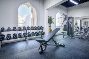 a gym with a bench and tread machines at Central Inn Souq Waqif in Doha