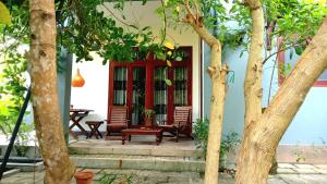 a house with a red door and a bench at My Home Villa in Hikkaduwa