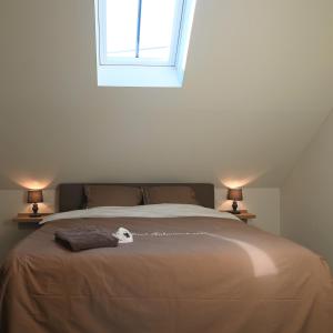 a bedroom with a large bed with two lamps at De Sint-Antoniushoeve in Zonnebeke