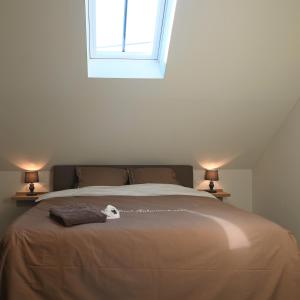 een slaapkamer met een groot bed met 2 lampen bij De Sint-Antoniushoeve in Zonnebeke