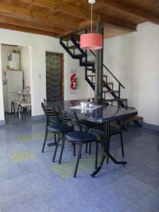 a dining room with a table and chairs and a spiral staircase at Del Carmen in Villa Giardino