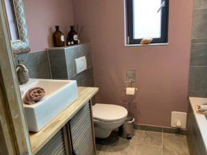 a bathroom with a white sink and a toilet at Wohnung Midcoast im Herzen von Schleswig-Holstein in Nortorf
