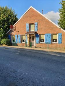 een bakstenen gebouw met blauwe ramen in een straat bij Ferienhaus Auszeit am Dollart 25195 in Bunde