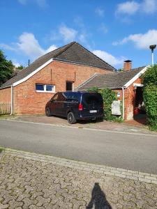 a van parked in front of a brick house at Ferienhaus Auszeit am Dollart 25195 in Bunde