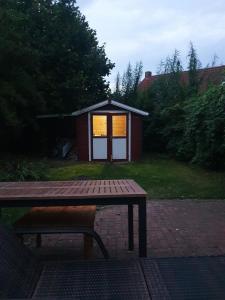 een picknicktafel en een kleine schuur met een licht bij Ferienhaus Auszeit am Dollart 25195 in Bunde