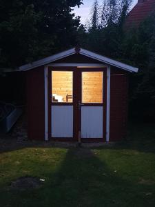 a small shed with a door and a window at Ferienhaus Auszeit am Dollart 25195 in Bunde