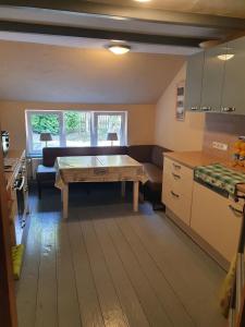 a kitchen with a table in the middle of a room at Ferienhaus Auszeit am Dollart 25195 in Bunde