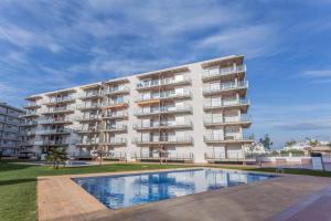 an apartment building with a swimming pool in front of it at Piso de 2 habitaciones, 3 piscinas y cerca del mar in Roses