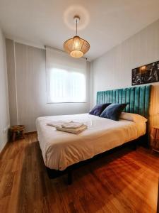 a bedroom with a large bed with a blue headboard at Casa Robledo in Palazuelos de Eresma