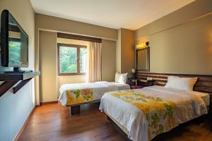um quarto de hotel com duas camas e uma televisão de ecrã plano em Gazelle Resort & Spa em Bolu