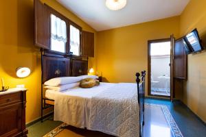 a bedroom with a bed with yellow walls and a window at B&B ANTICA KALAGONIS in Maracalagonis