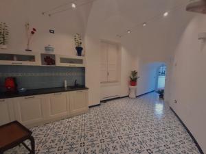 a large kitchen with white cabinets and a tile floor at Palazzo Della Guardia in Vietri sul Mare