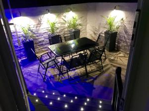 a table and chairs in front of a stone wall with lights at 77 Park Road Apartments in Blackpool