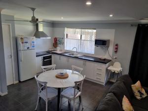 cocina con mesa y cocina con nevera en Ocean Beach Chalet 18, en Jurien Bay