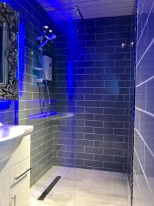 a bathroom with a shower with blue lights in it at 77 Park Road Apartments in Blackpool