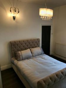 a large bed in a bedroom with a light fixture at 77 Park Road Apartments in Blackpool