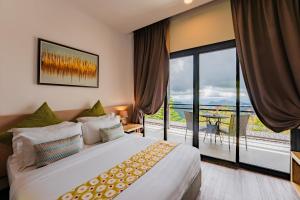 a bedroom with a large bed and a balcony at Mountain Valley Resort in Kundasang