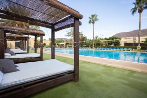 a bedroom with a bed and a swimming pool at Complejo Turístico Los Escullos San Jose in Los Escullos