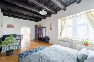 1 dormitorio con paredes blancas y techo de madera en St. George Apartments en Praga