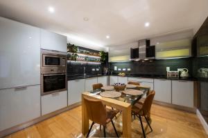ロンドンにあるLondon Nino Apartmentsの部屋にテーブルと椅子のあるキッチン