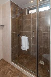 a bathroom with a glass shower with a towel at Lenana Suites in Nairobi