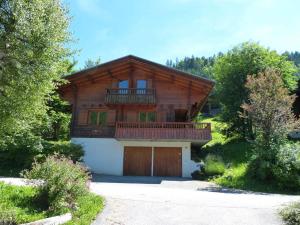 a large wooden house with a balcony and a garage at Chalet La Clusaz, 6 pièces, 10 personnes - FR-1-304-164 in La Clusaz