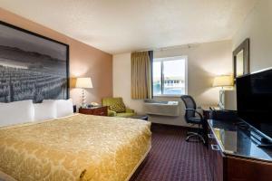 ein Hotelzimmer mit einem Bett und einem TV in der Unterkunft Super 8 by Wyndham Pendleton in Pendleton