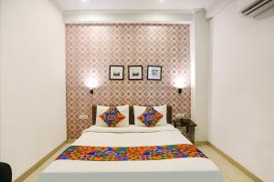 a bedroom with a bed and two pictures on the wall at FabHotel Novel Suites in New Delhi