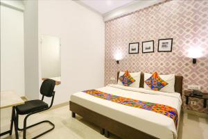 a bedroom with a bed and a desk and a chair at FabHotel Novel Suites in New Delhi