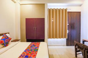 a bedroom with a bed and a cabinet in it at FabHotel Novel Suites in New Delhi