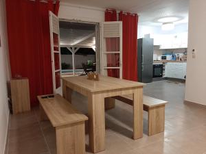 a kitchen with a wooden table and two benches at Villa Lunéa in Sainte-Luce