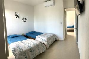 a room with two beds in a room with a hallway at Departamento 2 habitaciones vista a la alberca Nube by EITA in Cancún