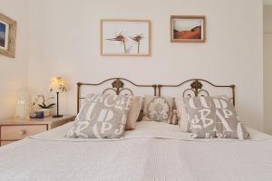 een slaapkamer met een bed met kussens erop bij Sunny Apart W Balcony in Algarve by LovelyStay in Ferragudo