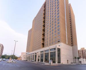 a large building on a street in a city at Al Hidayah Towers Hotel in Makkah