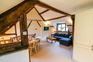 a living room with a blue couch and a table at Kestrel Cottage in Builth Wells