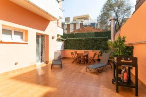 un patio con sedie e tavolo in un edificio di AB North Barcelona Apartments a Barcellona