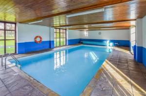 a large indoor swimming pool with a wooden ceiling at Kestrel Cottage in Builth Wells