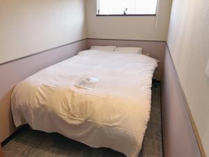 a small bed in a small room with a window at KIIIYA cafe&hostel in Azumino +51 photos