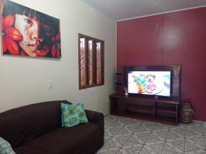 salon z kanapą i telewizorem z płaskim ekranem w obiekcie Recanto das Palmeiras Alter do Chão w mieście Alter do Chao